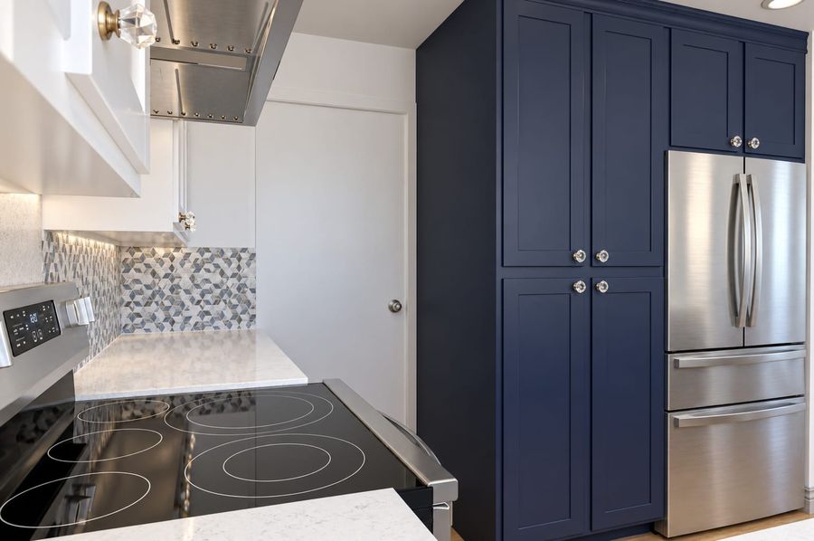 3D rendering of the same kitchen from beside the range: a glass cooktop, the navy floor-to-ceiling pantry with crystal knobs, and the refrigerator set into the cabinetry